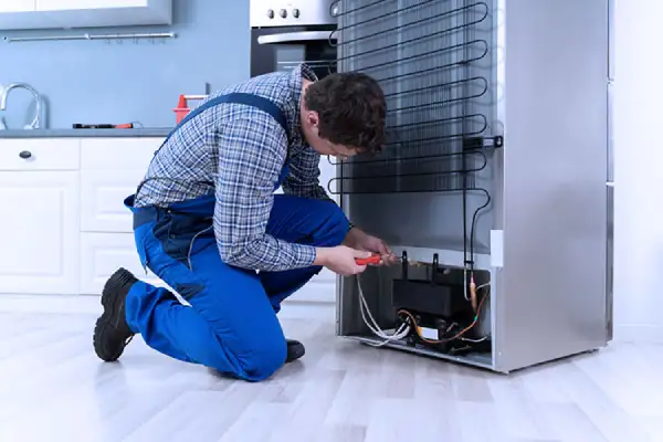 Technician is fixing freezer